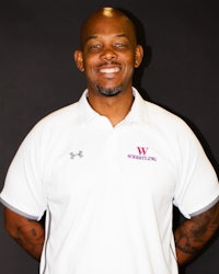a black man in a white polo shirt with tattoos