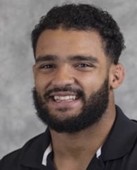 a man with a beard smiling for the camera
